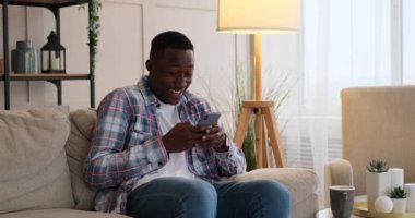 Neşeli adam evdeki cep telefonundan mesaj atıyor.