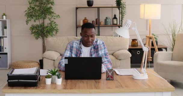 Empresario afroamericano trabajando en laptop y escribiendo notas — Vídeo de stock