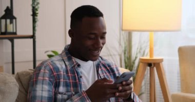 Cep telefonu kullanarak komik haberler okuyan ya da mesajlaşan adam