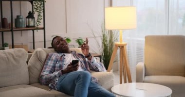 Evdeki kanepede dinlenen eğlenceli düşünceleri hatırlayan bir adam.