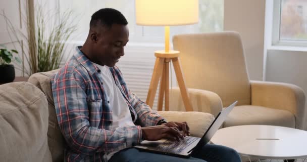 Człowiek śmieje się podczas rozmowy na laptopie w domu — Wideo stockowe