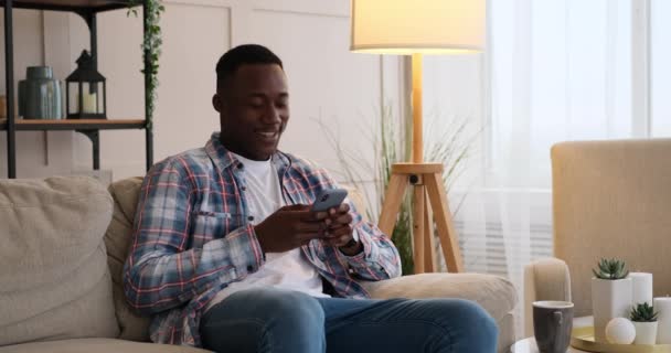 Mensajería de texto alegre hombre en el teléfono móvil en casa — Vídeo de stock