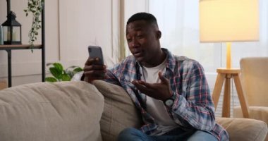 Evde cep telefonu kullanan bir adam görüntüsü sohbet ediyor.