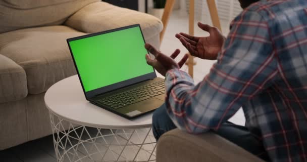 ผู้ชายวิดีโอแชทโดยใช้แล็ปท็อปที่มีหน้าจอปุ่มโครม่าสีเขียว — วีดีโอสต็อก