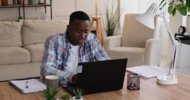 Yorgun işadamı fazla mesai yaparken esniyor ve zamanı kontrol ediyor.