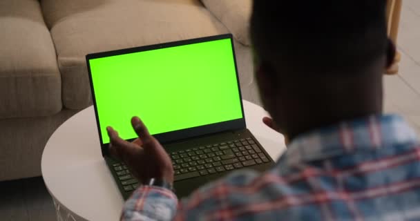 Man video chatta med hjälp av bärbar dator med grön chroma nyckel skärm — Stockvideo
