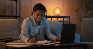 Kadın müzik dinliyor ve gece geç saatlere kadar çalışıyor.