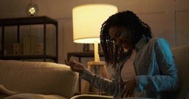 Kadın evde gitar çalıp dans ediyor.