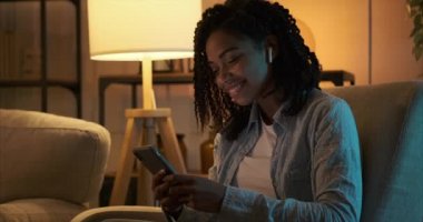 Cep telefonu ve kulaklık kullanan müzik dinleyen bir kadın