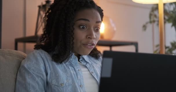 Mujer celebrando el éxito en línea utilizando el ordenador portátil en casa — Vídeo de stock