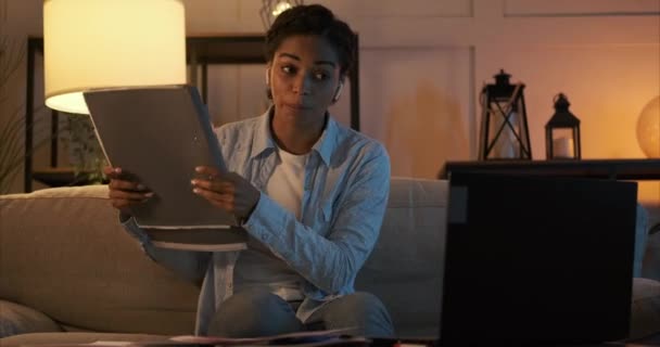 Femme discutant de paperasse et de papier déchirant pendant l'appel vidéo à l'aide d'un ordinateur portable la nuit — Video