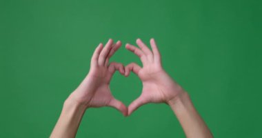Yeşil ekranın üzerinde elleri olan kalp şekli