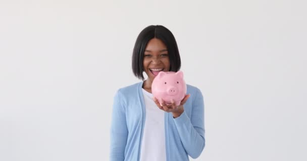 Mulher inserindo moeda no banco porquinho — Vídeo de Stock