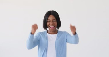 Kendinden geçmiş bir kadın beyaz arka planda başarıyı kutluyor