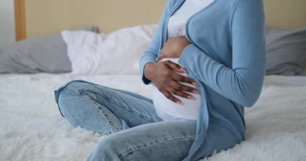 Hamile bir kadın evde karnını okşuyor. — Stok video