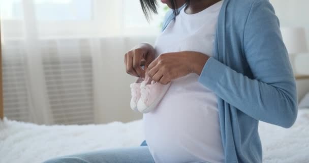 Lycklig kvinna gå baby skor på sin gravida mage hemma — Stockvideo