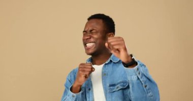 Bej arka plandaki zaferi kutlayan adam