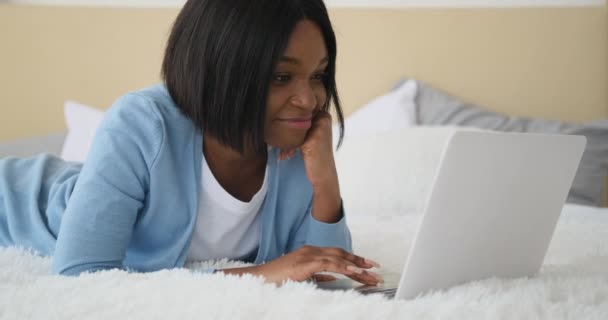 Γυναίκα που χρησιμοποιεί φορητό υπολογιστή ξαπλωμένη στο κρεβάτι — Αρχείο Βίντεο