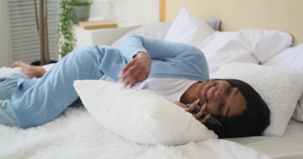 Mujer hablando por teléfono móvil acostada en la cama — Vídeo de stock