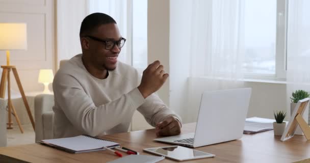 Мужчина развлекается, пользуясь ноутбуком в домашнем офисе — стоковое видео