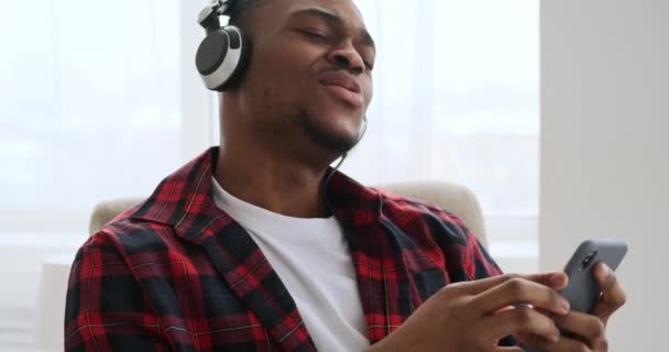 Άνθρωπος ακούει μουσική χρησιμοποιώντας κινητό τηλέφωνο και ακουστικά — Αρχείο Βίντεο