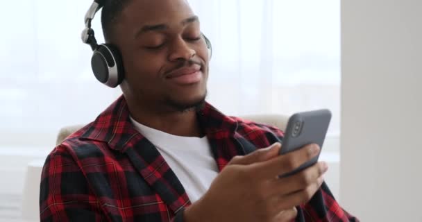 男人用手机和耳机听音乐 — 图库视频影像