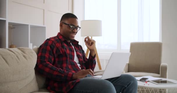 Glad man som använder laptop hemma — Stockvideo