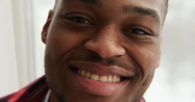 Evde gülümseyen kendinden emin bir adam.