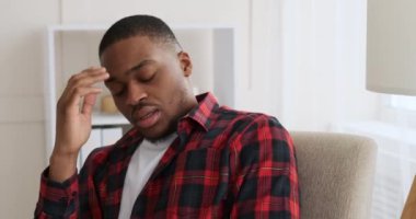 Sıkılmış ve yorgun adam koltukta oturuyor.