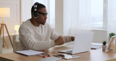 Erkek video konferansı dizüstü bilgisayar ve kulaklıkla yapılıyor