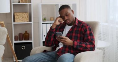 Sıkılmış adam cep telefonunu evde atıyor.