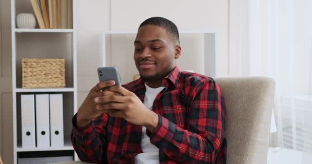 Uomo divertirsi utilizzando il telefono cellulare a casa — Video Stock