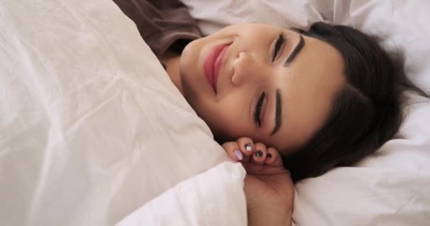 Bir kadın uyanıyor ve yatakta geriniyor. — Stok video