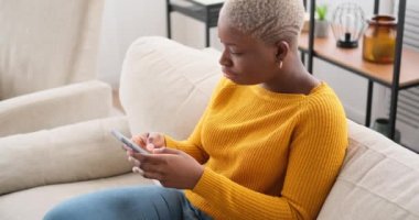 Evde cep telefonu kullanan mutlu kadın.