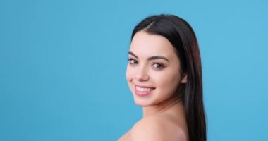 Güzel bir kadın uzun siyah saçlarıyla dönüyor.