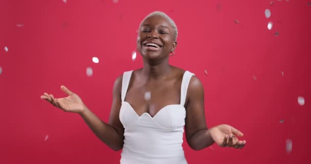 Cheerful woman laughing under silver confetti shower — Αρχείο Βίντεο