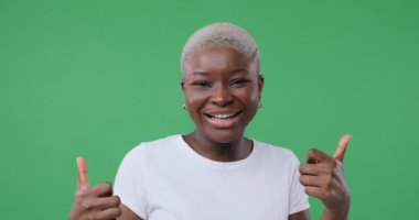 Kadın baş parmak işareti yapıyor ve dans ediyor.