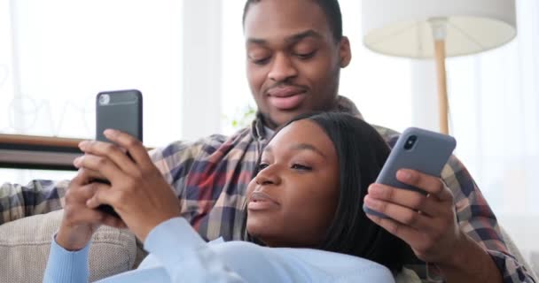 Casal usando telefones celulares em casa — Vídeo de Stock