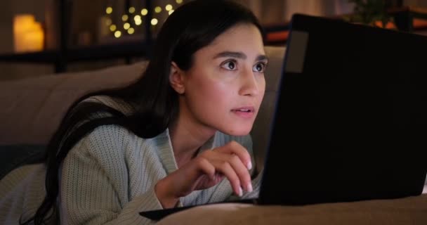 Vrouw viert online succes op laptop laat in de avond — Stockvideo