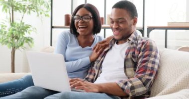 Çift gülerken dizüstü bilgisayar kullanıyor