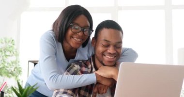 Çift gülüyor ve dizüstü bilgisayar kullanıyor 