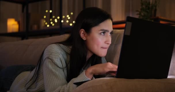 Geceleri dizüstü bilgisayar kullanan bir kadının aklına iyi bir fikir geliyor. — Stok video