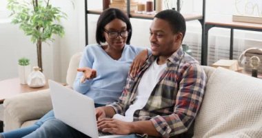 Koca dizüstü bilgisayar kullanıyor ve karısıyla konuşuyor.