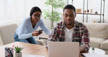 Kocasına cep telefonu içeriğini gösteren ve dizüstü bilgisayarla tartışan eş