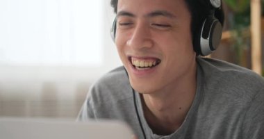 Erkek video konferansı dizüstü bilgisayar ve kulaklıkla yapılıyor