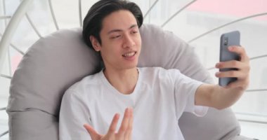 Evde cep telefonu kullanan bir adam görüntüsü sohbet ediyor.