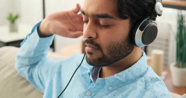 Nyugodt fiatalember zenét hallgat fejhallgatón — Stock videók