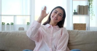 Woman greeting and sending flying kiss while video chatting