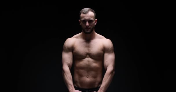 Man flexing muscles in studio — Stockvideo