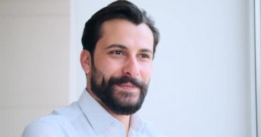 İş adamı başka tarafa bakıyor ve gülümsüyor.